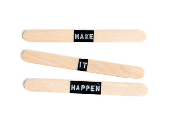 Inscription make it happen, on wooden popsicle sticks, on white background.