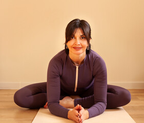 Portrait of a middle-aged woman doing yoga at home.