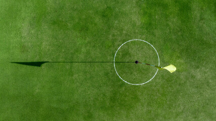 Top view putting green with flag at golf course, Golf Course with putting green, Golf course sport, green grass on golf field, fairway and putting green top view.