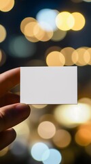 Blank business card held against a blurred night city backdrop