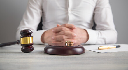 Divorce judge with a gavel and wedding rings.