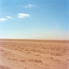 Vast, empty desert landscape under a clear blue sky.