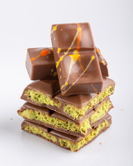 Dubai chocolate bar with filling made of kataifi (knafeh, kadayif) and pistachio  paste. Trendy chocolate on white background. Close-up.