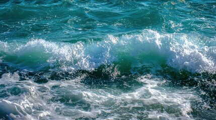 Obraz premium Clear turquoise waves roll gently toward the sandy shore, creating a peaceful atmosphere. Sunlight reflects off the water on a calm day, enhancing the serene setting