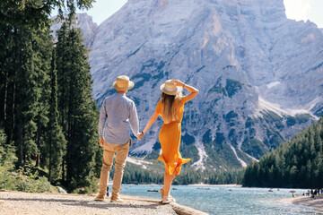 couple holding hands and admiring the view of Dolomites, Italy.