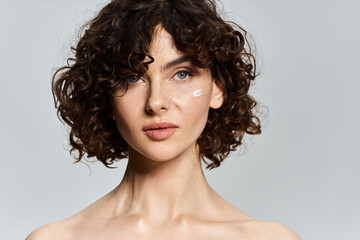 Elegant woman highlights her flawless complexion and glowing skin against a serene backdrop