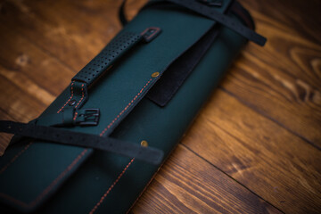 Elegant Handmade Leather Roll with Buckles on Wooden Surface in Close-Up View