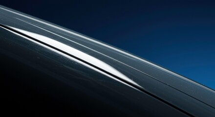 Sleek Car Design: Capturing a close-up view of a car's smooth, metallic contours and reflective surface, with a contrasting backdrop that highlights its polished finish.