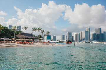 Miami beach with outdoor cafe and white sand with coconut palm trees