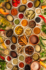 Assorted spices and herbs on a beige background, offering rich scents and vibrant colors, ideal for adding depth and warmth to any culinary creation