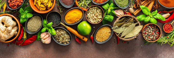 A rich palette of colorful spices and herbs, resting on a brown background, radiating freshness and...
