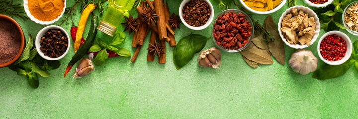 A beautiful collection of colorful spices and herbs, showcasing their natural aromas and vibrant hues on a gentle green background, top view and copy space, banner