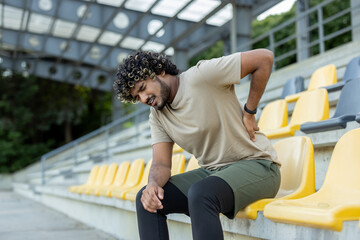 Athlete suffers from back pain, man injured while jogging and doing active physical exercises and...