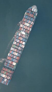 Navire cargo transportant des conteneurs sur une mer calme, captur&eacute; en vue a&eacute;rienne