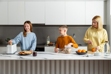 Family preparing healthy breakfast together in modern kitchen