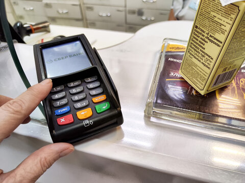 Kirov, Russia - January 29, 2025: Payment process at a checkout counter in a retail store with a card reader device