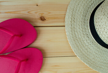 Summer vacation, flatlay. Hat and flip flops on a wooden background.