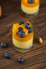 Double colored vegan mango panna cotta mousse pudding with blueberries and coconut cream. Sugar,...