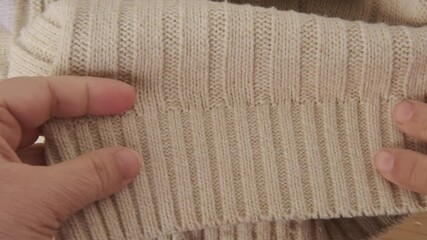 female Hand touching knitted wool cloth or warm fluffy sweater, Handcraft knitting woolen fabric surface, tactile properties, fabric testing - Powered by Adobe