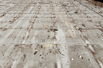 old asbestos sheets from a roof covered with dirt