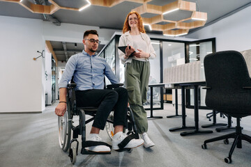 Business colleagues, collaborative business colleagues, including a person in a wheelchair, walk...