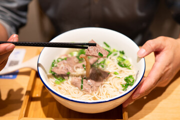 man is eating beef noodles