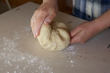 a woman kneads dough with her hands