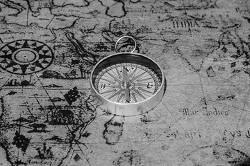 Classic round compass on background of old vintage map of world