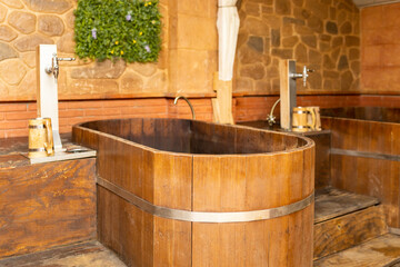 Photograph of a spa with bathtubs filled with beer with wooden materials.
