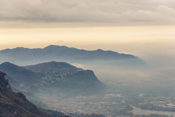 top view of the Como Lake from the Resinelli Piani in a foggy morning, Lecco province, Italy