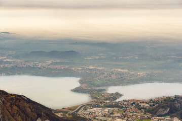 Fototapeta premium top view of the Como Lake from the Resinelli Piani in a foggy morning, Lecco province, Italy