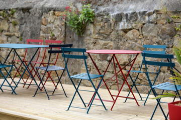 Empty street caf&eacute; with vacant tables and chairs during the off-season. Quiet urban scene expressing calm, stillness, and peaceful atmosphere in a city public space.
