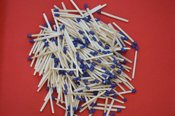 A close up of a set of wooden matches arranged on an isolated dark background. The match heads are...