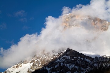 clouds over the snow covered mountains