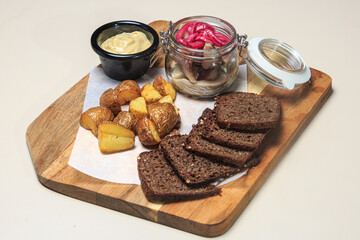 a wooden serving board with a variety of appetizer-style items arranged on it. 