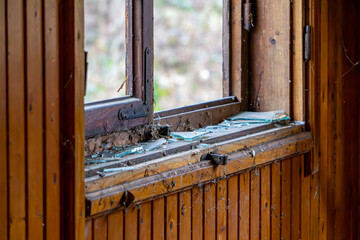 broken window in an old wooden house in the countryside. vandalized window in a wooden house.