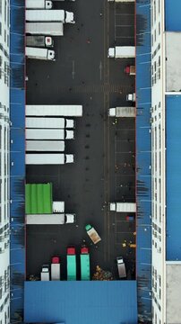 Vue a&eacute;rienne d&rsquo;un centre logistique avec des camions align&eacute;s dans une cour industrielle
