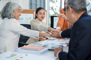 Diverse business team clasping hands, displaying unity and celebrating collaborative success during corporate team building meeting