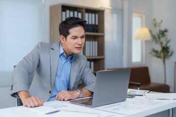 Professional experiencing anxiety while analyzing negative financial report on laptop, showing stress from declining market performance in contemporary workspace