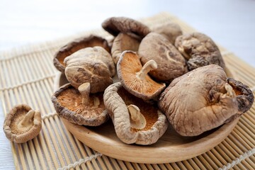Dried mushrooms in wooden plate , Deied shiitake mushrooms on white background	