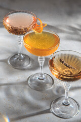 The image shows three elegant cocktail glasses with different colored drinks. 
