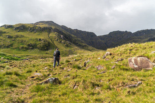 Hicker on the trail to Mweelrea mountain with Ben Lugmore peaks in the distance, the Atlantic coast of County Mayo, Ireland.