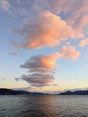 夕暮れの空に浮かぶ幻想的な雲と海の風景縦型