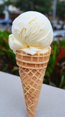 Vanilla ice cream cone outdoors, city background