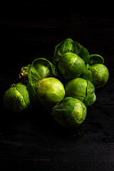 Top view of brussels sprouts on table and black background, vertical with copy space