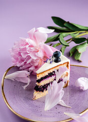 delicate piece of cake on a pink background with pink peony petals