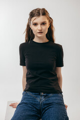 Obraz premium Stylish blonde girl wearing black t-shirt posing in studio