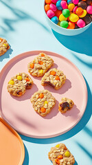 Colorful candy-studded cookies on pink plate with bright background