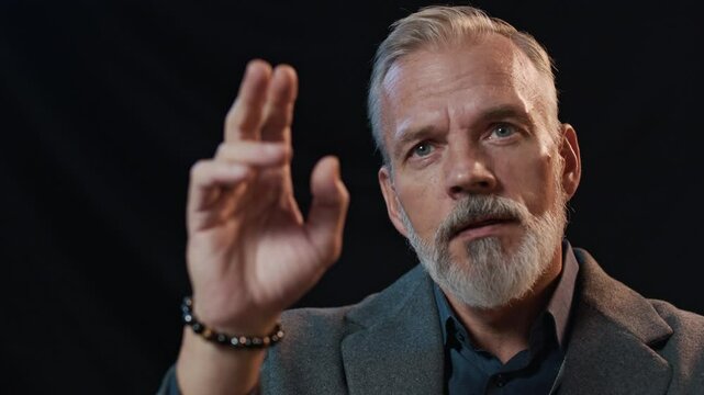 Middle-aged Caucasian man wearing suit raising his hand to ask question during business conference