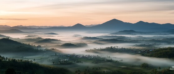Mist drapes over a sprawling landscape at dawn, with layers of mountains under an awakening sky, promising a day of exploration.